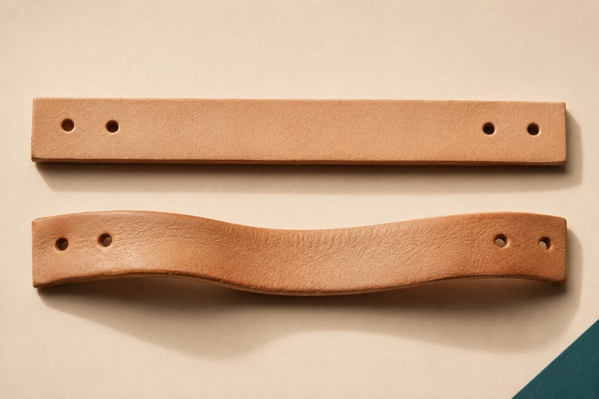 A stiff new leather strap beside the same strap after break-in, visibly softened and curved