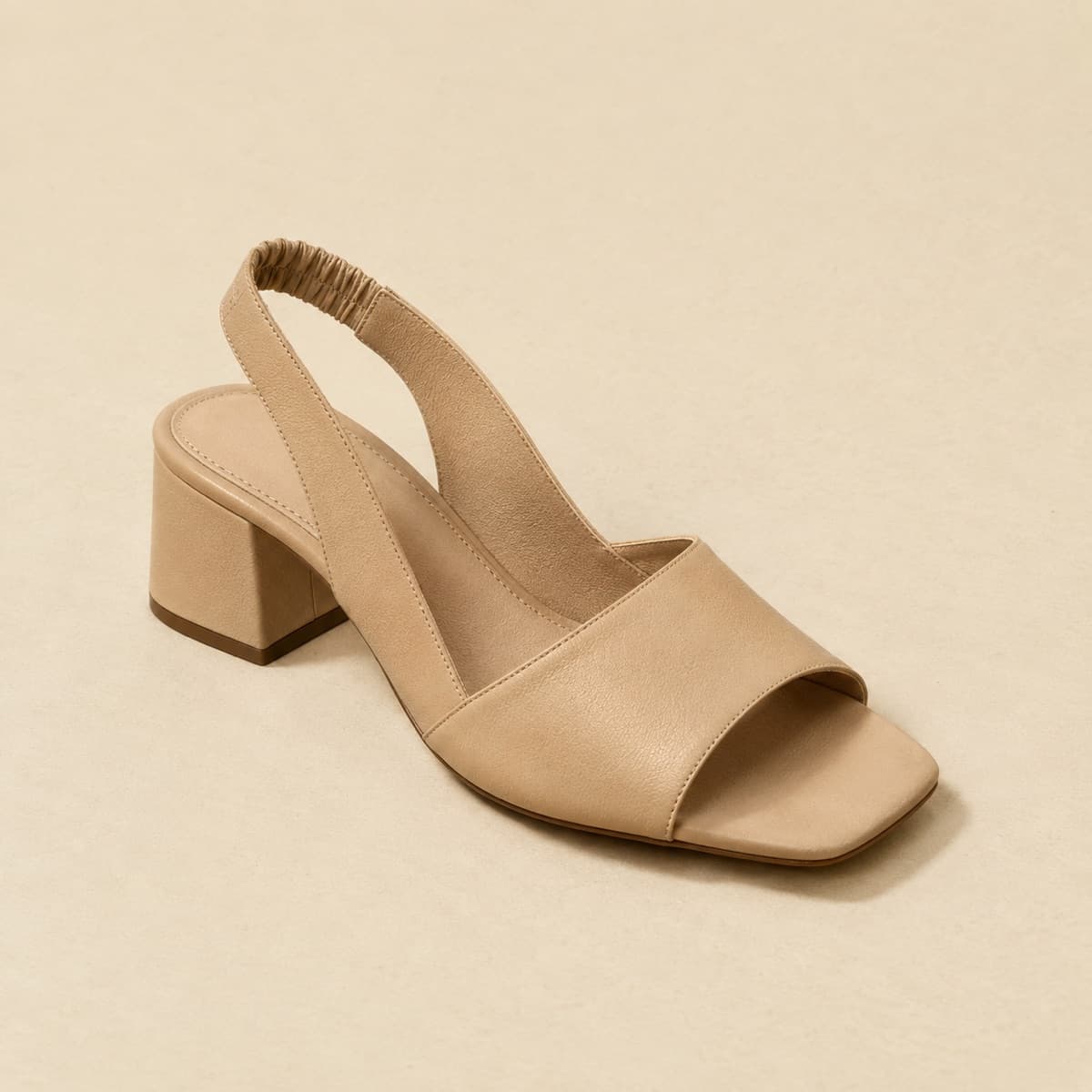 Heel Slingback, photographed from above against a sand-beige background