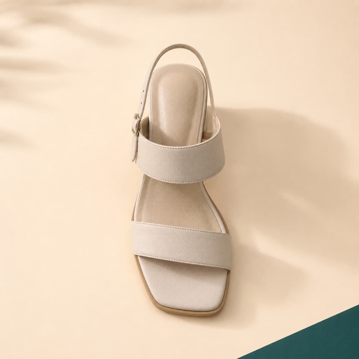 Heel Wide Fit, photographed from above against a sand-beige background